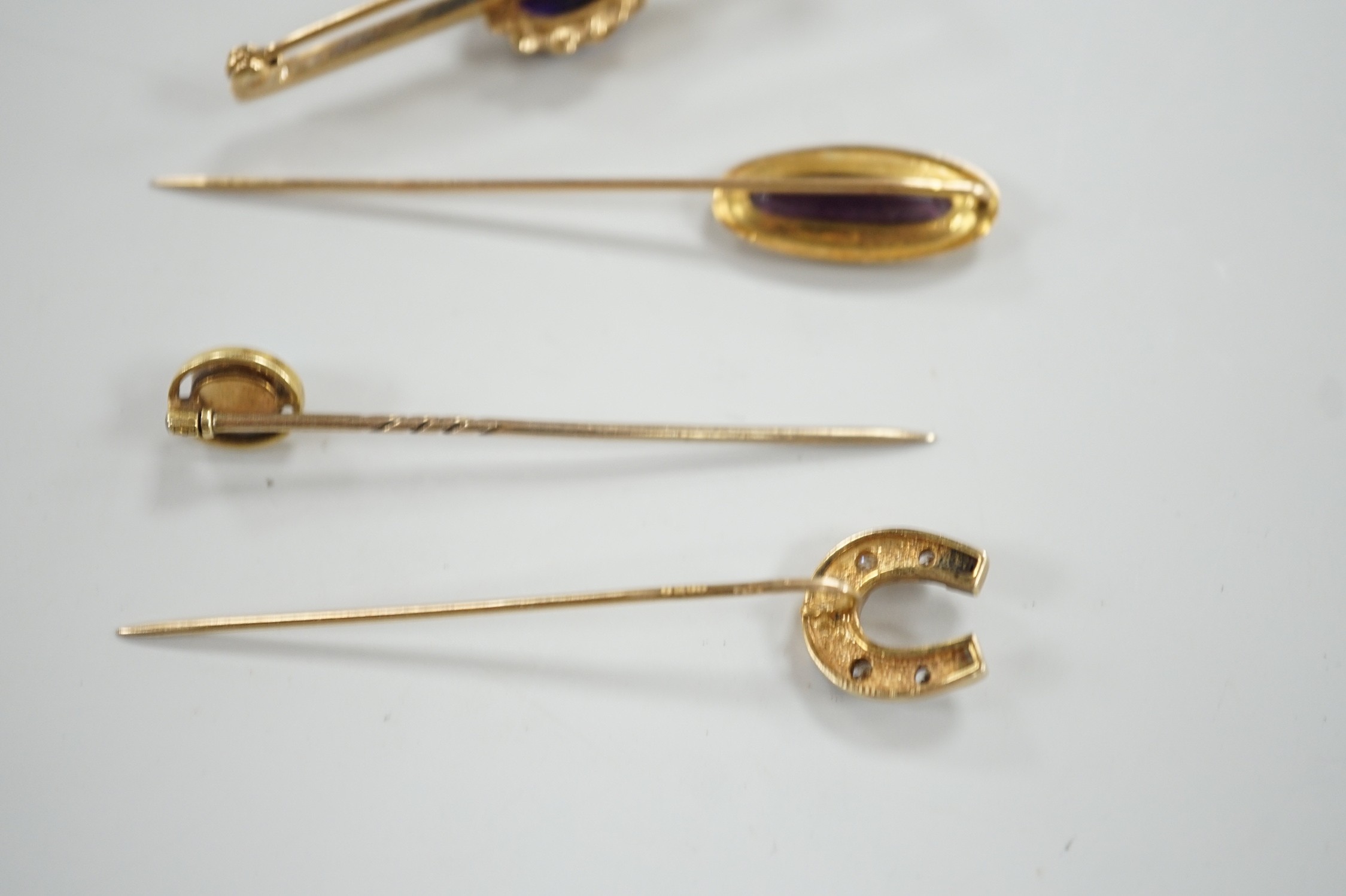 Three assorted yellow metal and gem set stick pins, including 9ct gold and diamond set horseshoe, 58mm and a modern 9ct gold and gem set bar brooch, gross weight 9.2 grams.